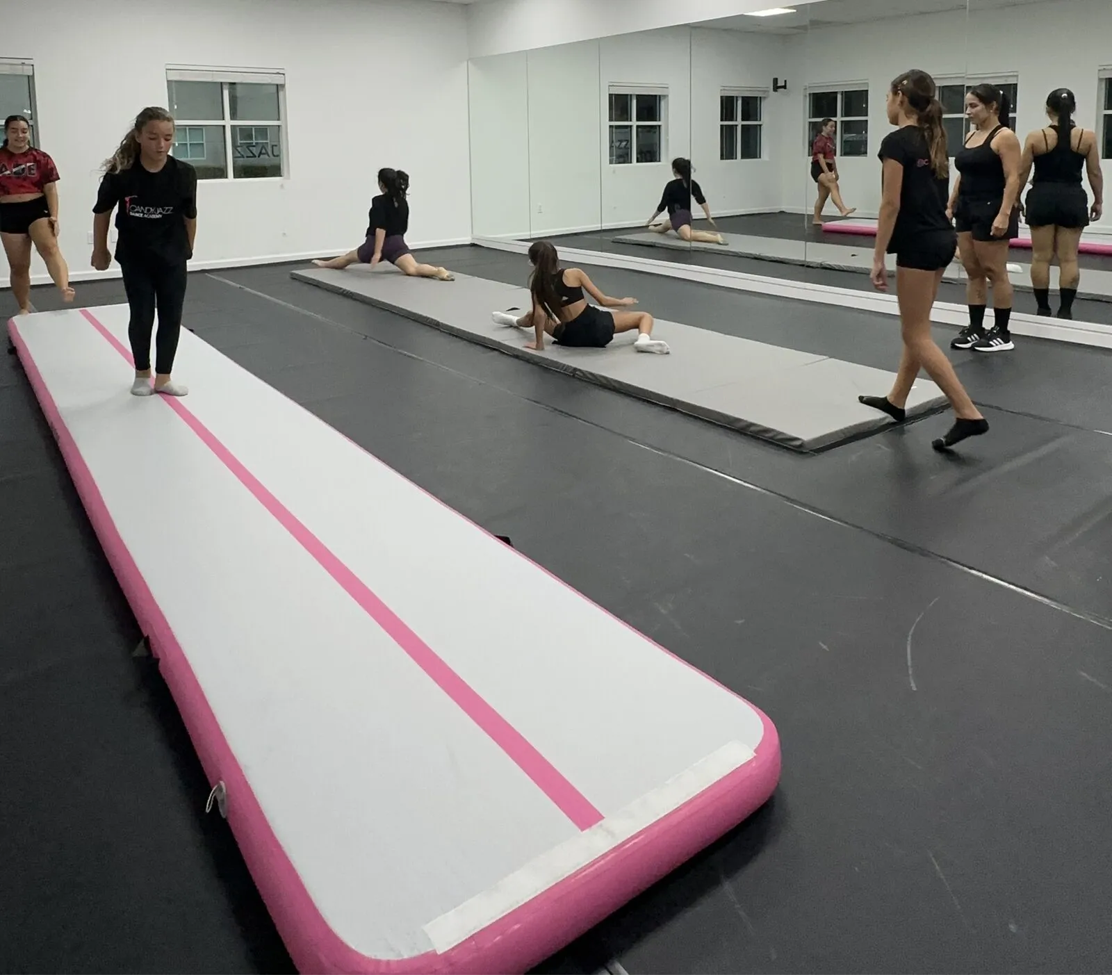 Candy Jazz Acro students training on tumbling mats in the studio