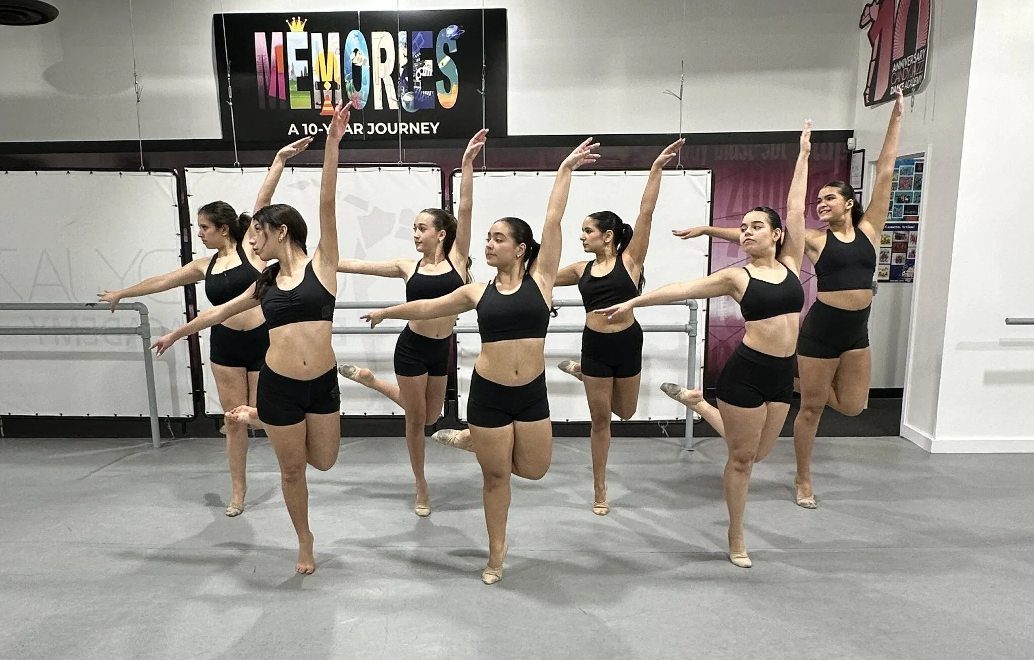 Seven Candy Jazz jazz dancers in a studio formation with raised arms