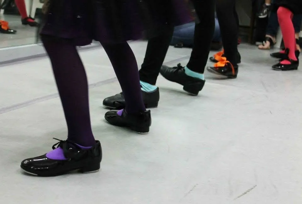 Tap dancers practicing rhythm and footwork in the studio