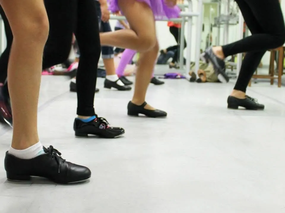 Tap dancers practicing rhythm and footwork in the studio