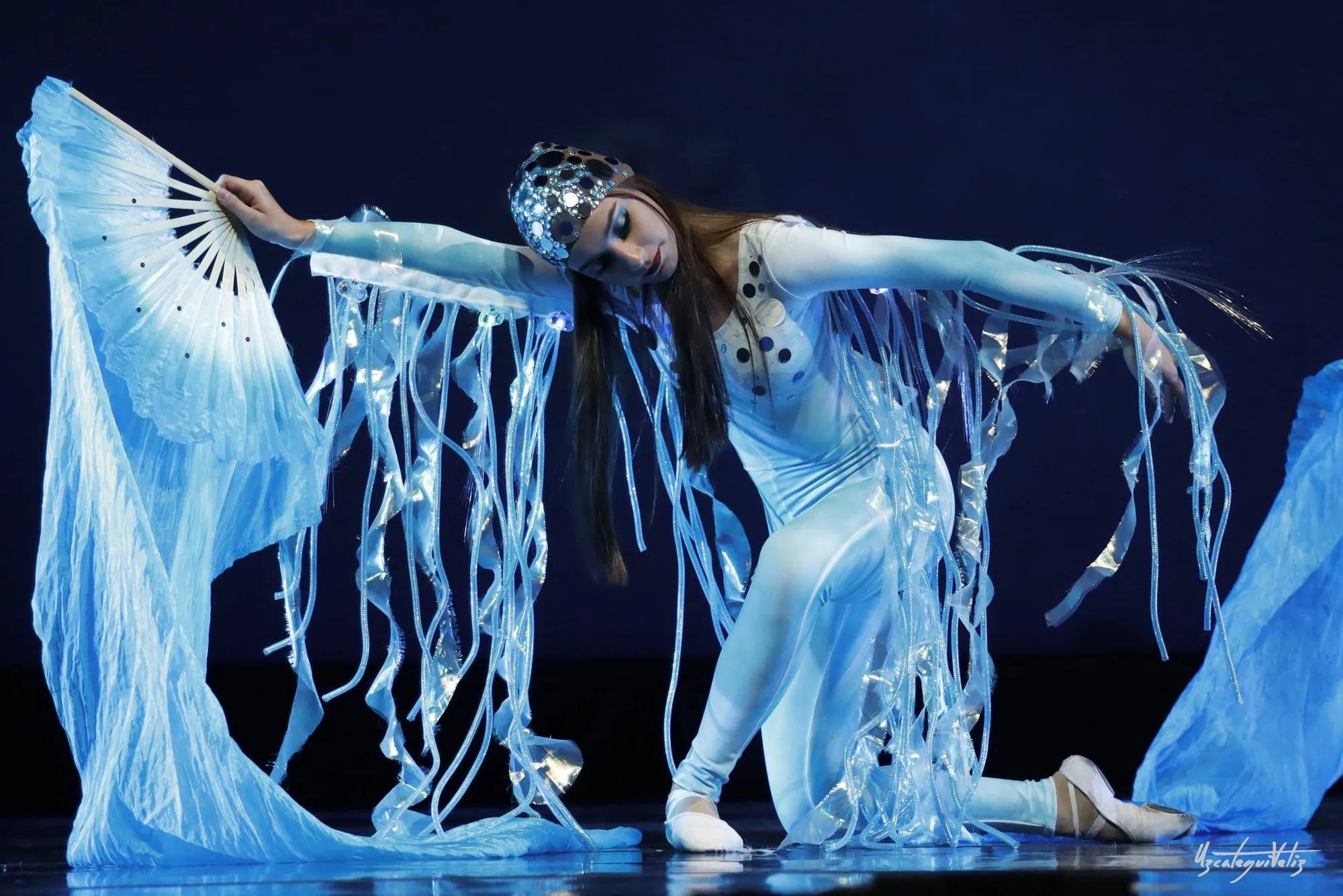 A Candy Jazz dancer performing a solo under blue stage light